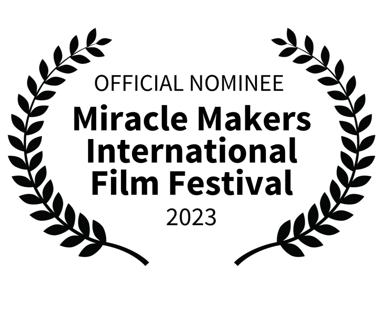 La imagen muestra un logo de nominación oficial en un festival de cine. El texto dice:

OFFICIAL NOMINEE
Miracle Makers International Film Festival
2023

Una corona de laurel rodea parcialmente el texto, con una rama a cada lado que se curva hacia el centro superior. Las ramas de laurel están negras al igual que el texto, y el fondo es blanco, lo que da un contraste claro y nítido.